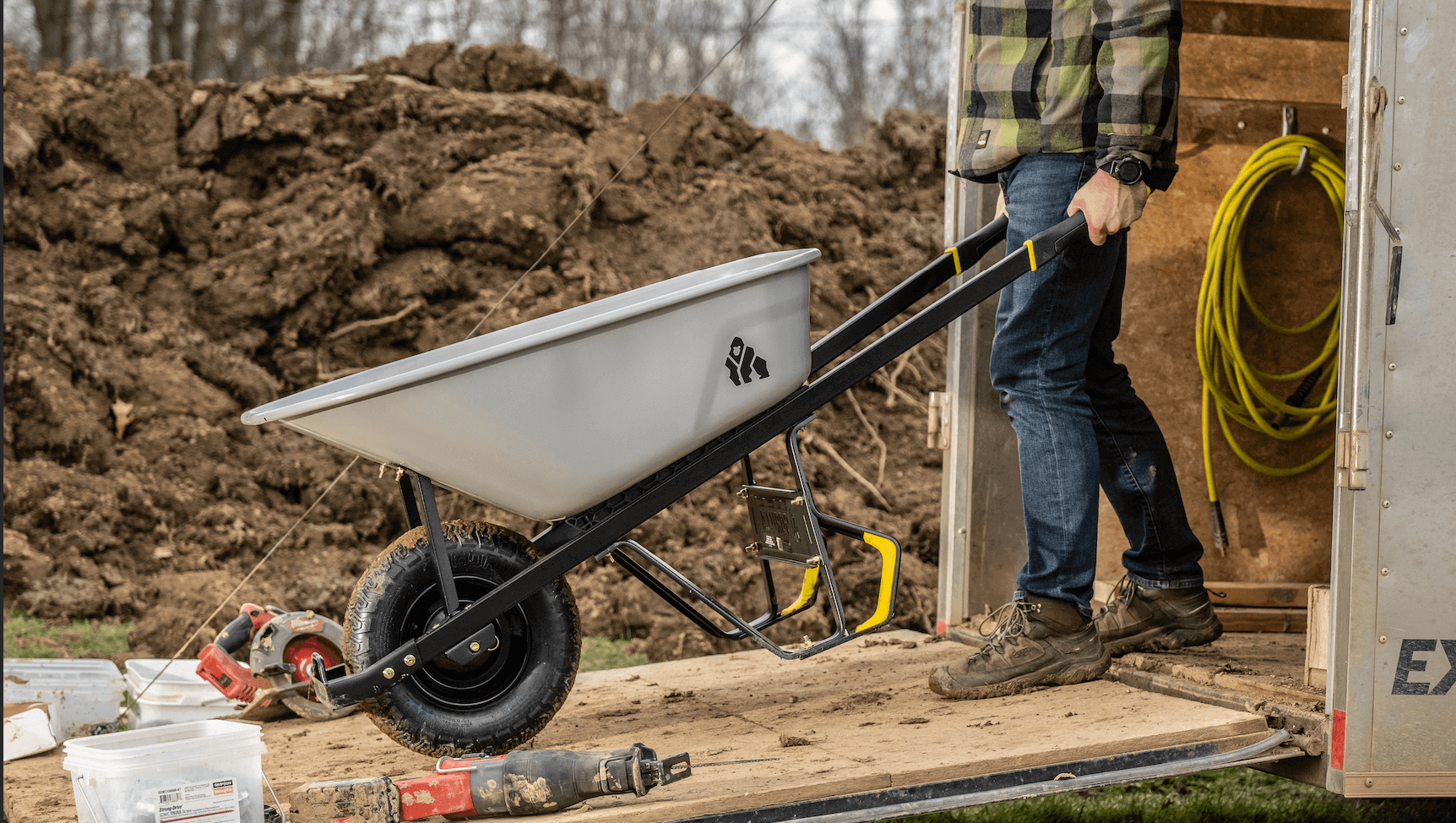 Guy pushing 6 CU Wheelbarrow out of a trailer